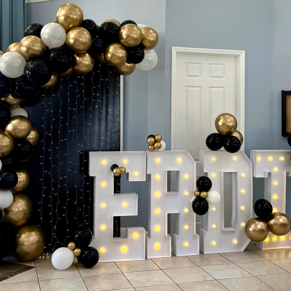 East Ridge Dance Team Banquet balloon garland setup in black, white, and gold with light up marquee letters